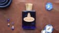 Roberto Ugolini Blue Suede Shoes Fragrance layflat on brown leather with blue accessories