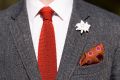 Knit Tie in Solid Rust Orange Silk in white long sleeve and gray suit with an edelweiss boutonniere and burnt orange silk pocket square all accessories by Fort Belvedere