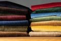 14 colors of Fort Belvedere trousers stacked on top of a wooden table