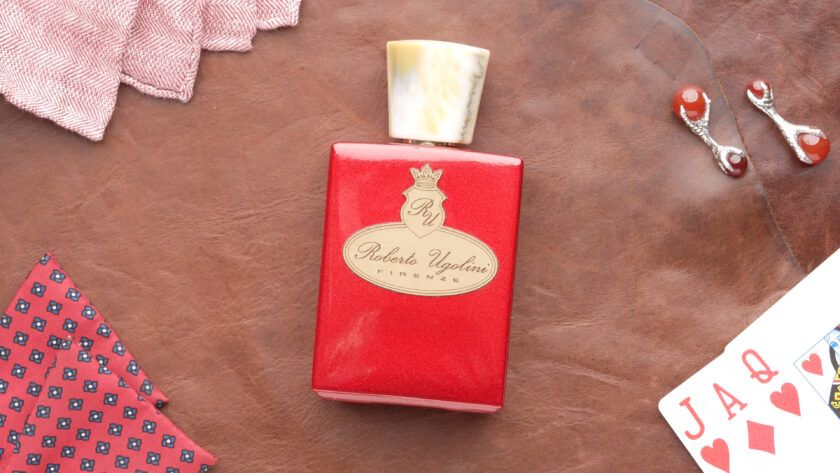 Roberto Ugolini 17 Rosso Fragrance bottle layflat with leather background and decorations in rd