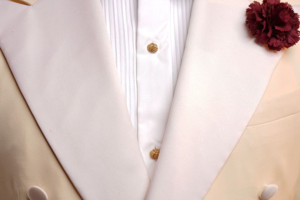 Yellow Gold Studs with carnation and burgundy boutonniere with off white dinner jacket