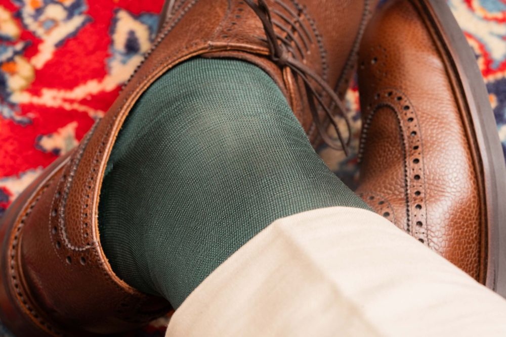 Up close of 280 needle-created silk sock - Over The Calf in Bottle Green Silk with Chinos and Brown Scotch grain brogues