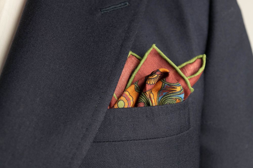 Brick Red Pocket Square Art Deco Egyptian Scarab pattern in green, orange, yellow, blue with green contrast edge by Fort Belvedere - Crown and Puff mix fold