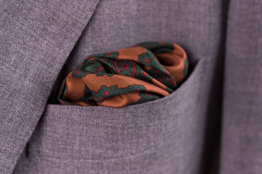 Real Ancient Madder Bronze, Burgundy and Bottle Green pocket square in a rakish puff fold with burgundy knit tie by Fort Belvedere