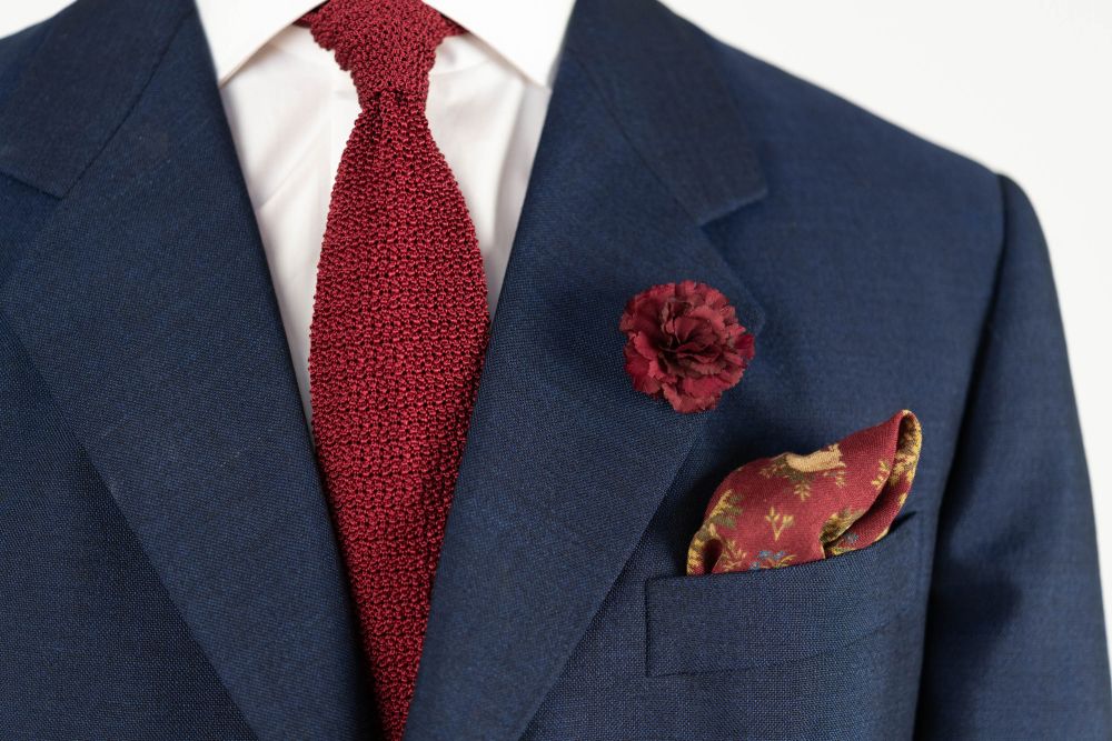 Burgundy Mini Carnation Silk Boutonniere Buttonhole Flower combined with Burgundy Red Knit Tie and Burgundy Silk Pocket Square - all accessories by Fort Belvedere