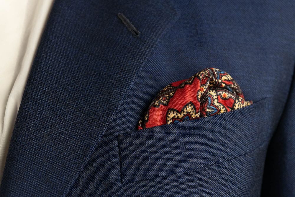 Cardinal Red Silk Wool Pocket Square with Printed geometric medallions in blue, black with buff contrast edge by Fort Belvedere - Puff fold