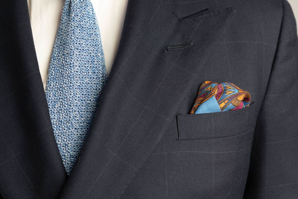 Cerulean Blue Pocket Square Art Deco Egyptian Scarab pattern in burnt orange, magenta, black with orange contrast edge by Fort Belvedere with  Blue-gray knit tie - Puff fold