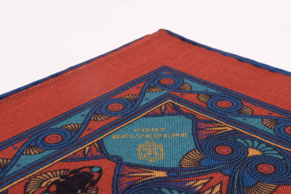 Edge of Copper Red Pocket Square Art Deco Egyptian Scarab pattern in royal blue, teal, yellow, with blue contrast edge by Fort Belvedere