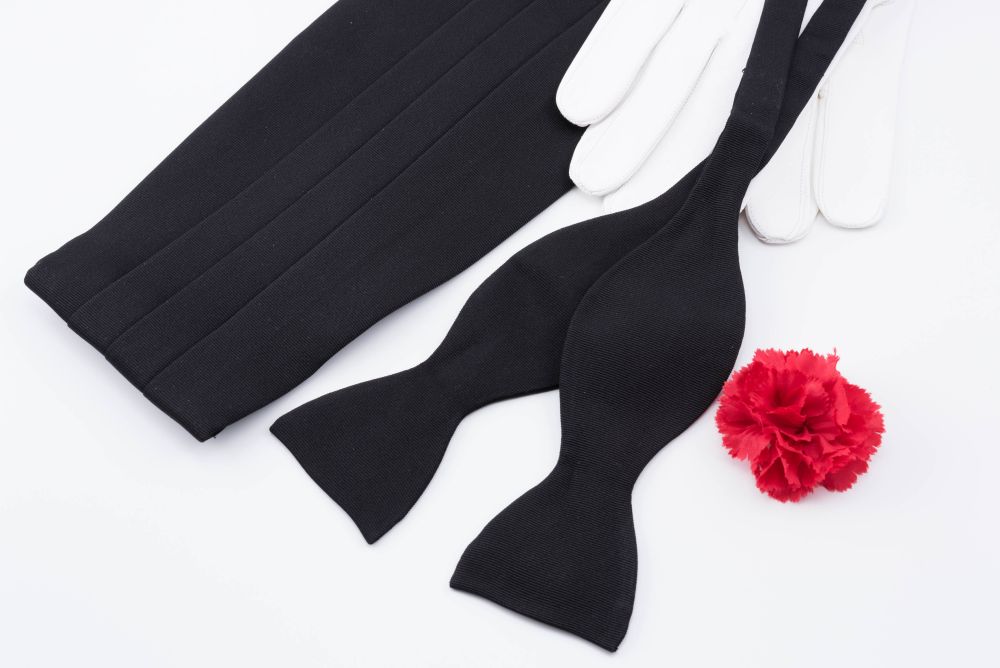 Cummerbund in Black Silk Faille Grosgrain Repp with Black bow tie in Silk Faille Grosgrain and Red Carnation Boutonniere and White unlined Leather Gloves