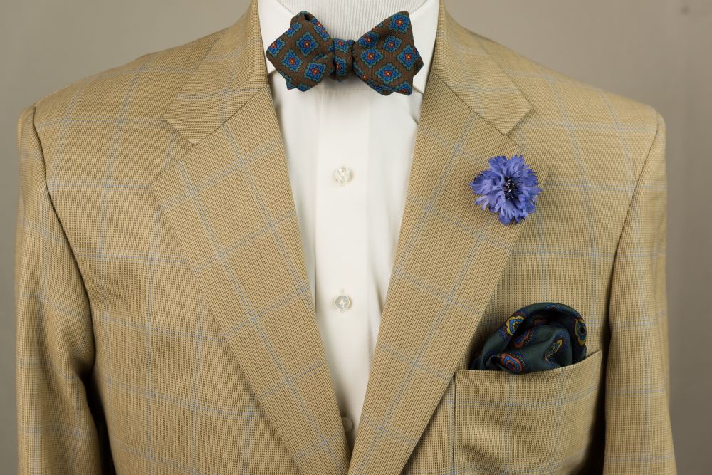 Wool Challis Bow Tie in Brown with Green, Blue, Red & Yellow Pattern & Blue Cornflower Boutonniere &  Dark Green Silk Pocket Square- Fort Belvedere