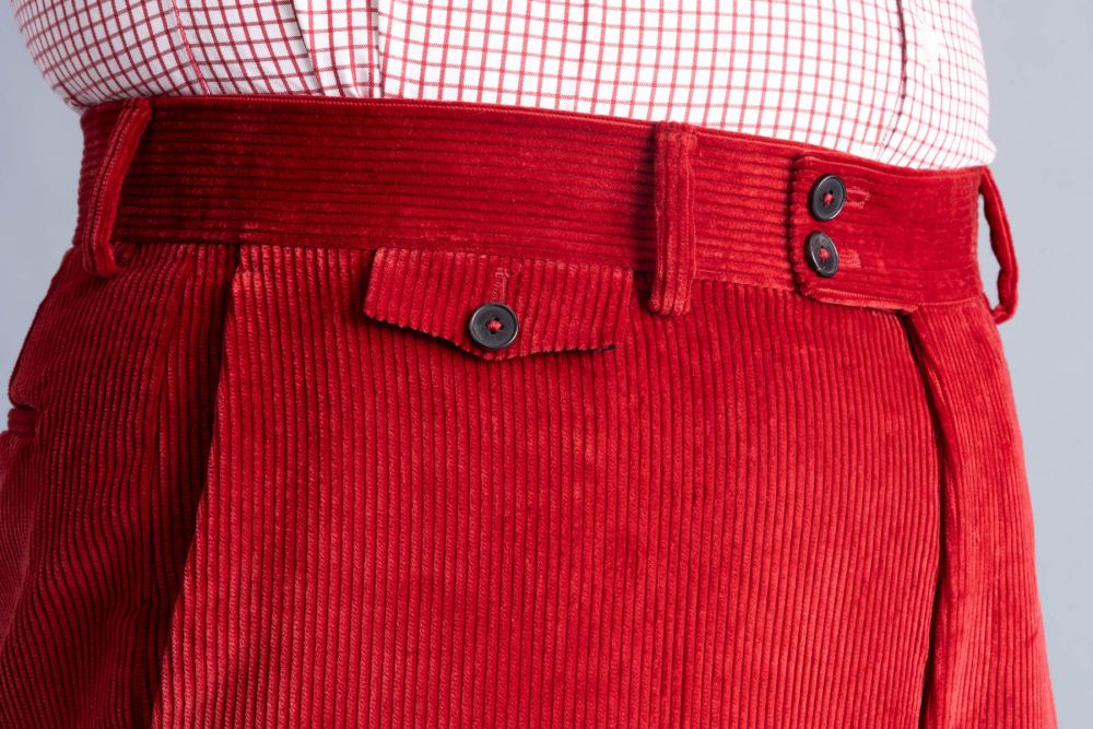 Flapped ticket detailed view pocket on Garnet red corduroy trousers. 