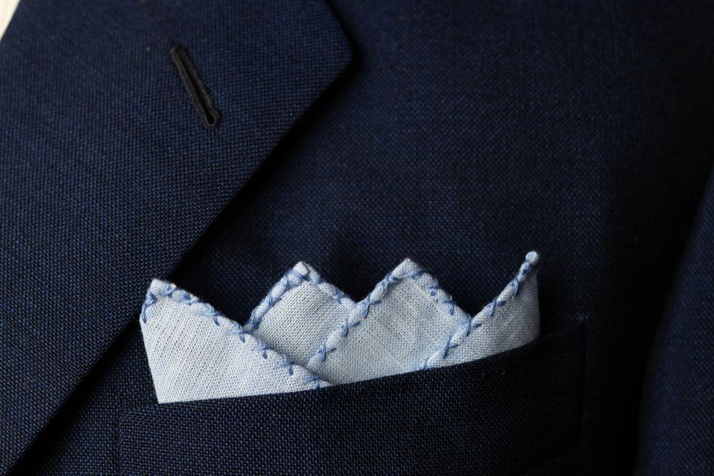 Light Blue Linen Pocket Square with Blue Handrolled Cross X Stitch - Fort Belvedere - Crown Fold