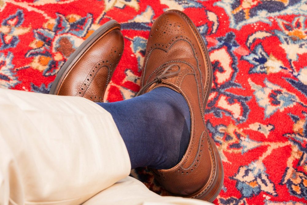 Point of view shot of brown full brogues paired with Over the Calf Silk Socks in Light Navy by Fort Belvedere