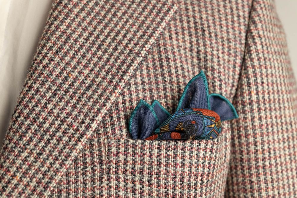 Sapphire Blue Pocket Square Art Deco Egyptian Scarab pattern in burnt orange, yellow, madder blue with teal contrast edge by Fort Belvedere - Crown and Puff mix fold