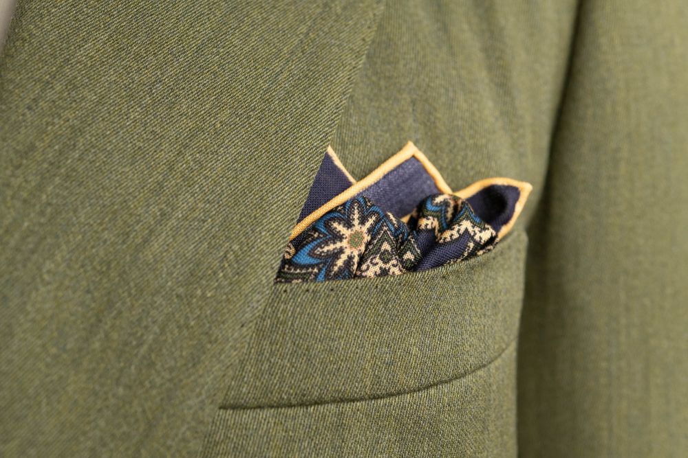 Navy Blue Silk Wool Pocket Square with Printed geometric medallions in green, blue and orange with off-white contrast edge - Fort Belvedere in olive green suite - Crown and Puff mix fold