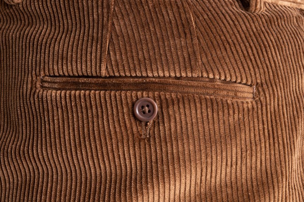 One of two jetted back pockets with button closure on Cognac Brown Stancliffe Corduroy pants by Fort Belvedere.
