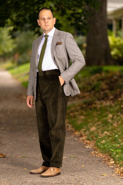 Raphael wearing a gray jacket paired with Dark Olive corduroy trousers. 