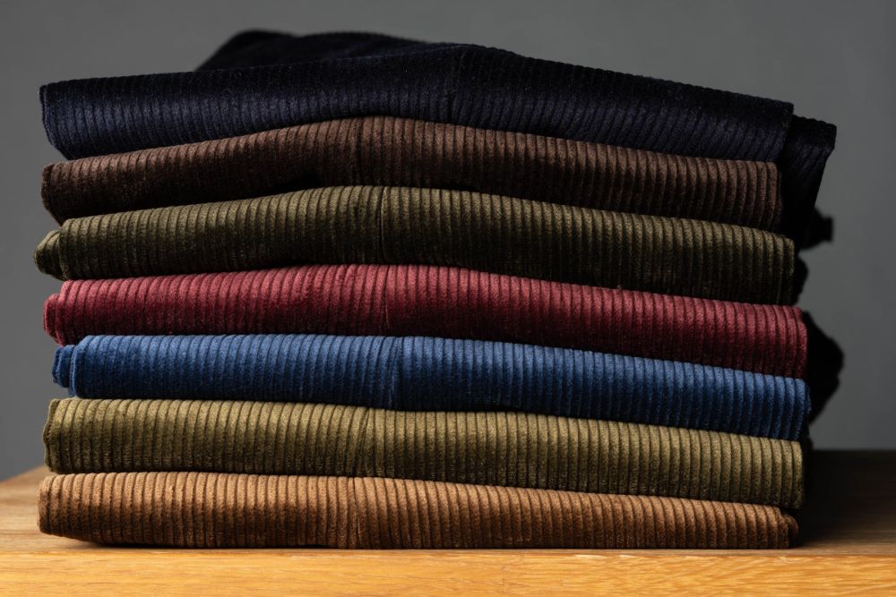 Casually stacked Fort Belvedere Corduroy pants in multiple colors, including the dark brown one.