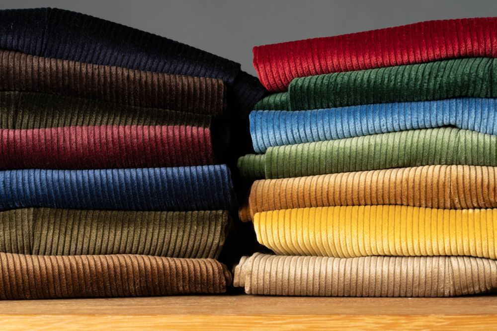 14 Colors of Stancliffe Corduroy trousers neatly stacked in two stacks showing the beautiful impact of the light on the color and look of the pants