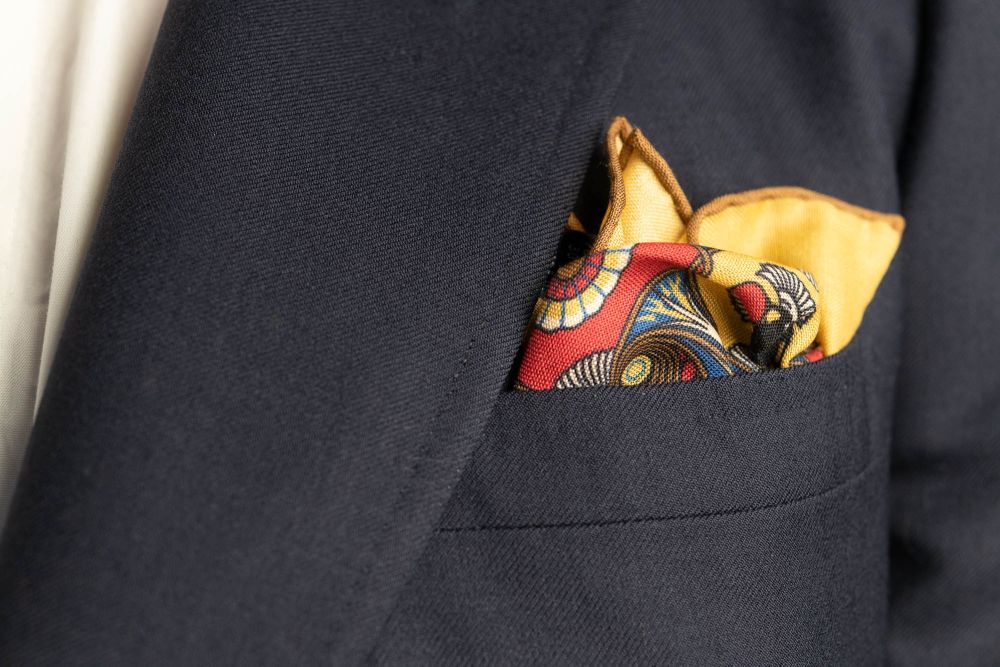 Straw Yellow Pocket Square Art Deco Egyptian Scarab pattern in antique brass, blue, black, cardinal red with brown contrast edge by Fort Belvedere - Crown and Puff mix fold