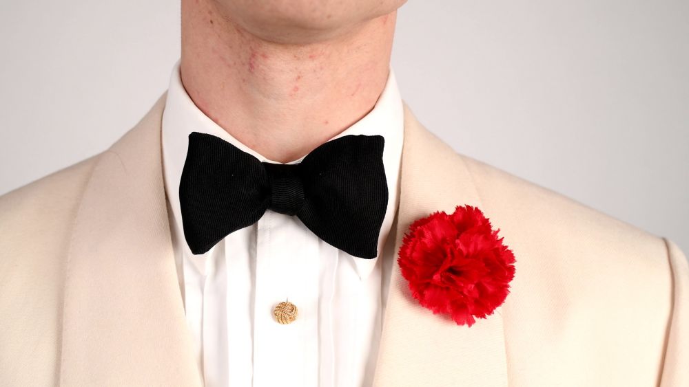 Yellow Gold Studs with carnation and black bow tie with off white dinner jacket