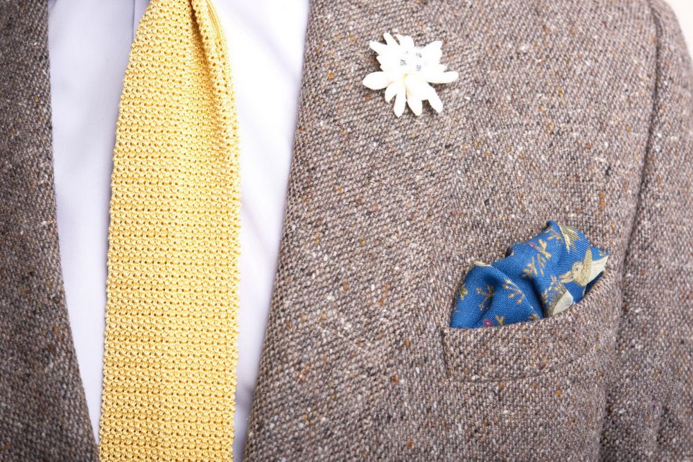 Yellow knit tie with tweed coat, Edelweiss boutonniere and  blue pocket square by Fort Belvedere
