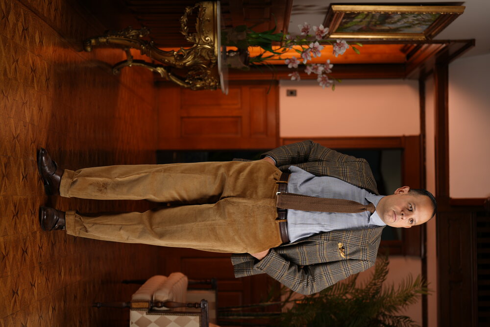 Sven Raphael Schneider modelling the Stancliffe Corduroy Trouers in Camel wearing it with a sport coat, double monk strap shoes and brown knit tie