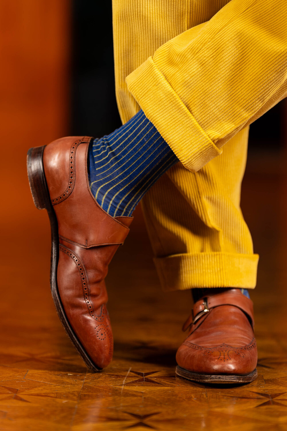 Goldenrod Corduroy trousers with cuffs paired with brown monk straps and Navy and Khaki Shadow Stripe Ribbed Socks.
