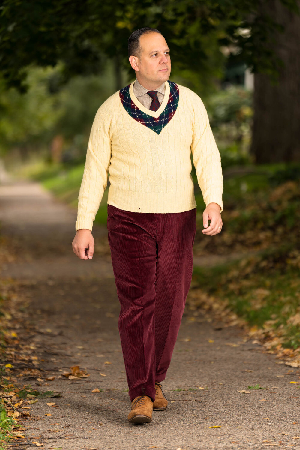 Raphael wearing a yellow knit sweater paired with the Maroon corduroy trousers. 