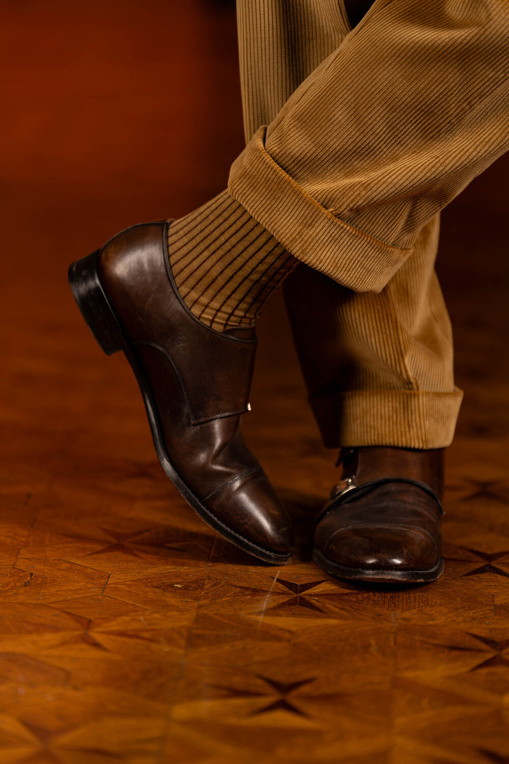 Camel Corduroy trousers with cuffs paired with brown monk straps and Caramel and Dark Burgundy Shadow Stripe Ribbed Socks.