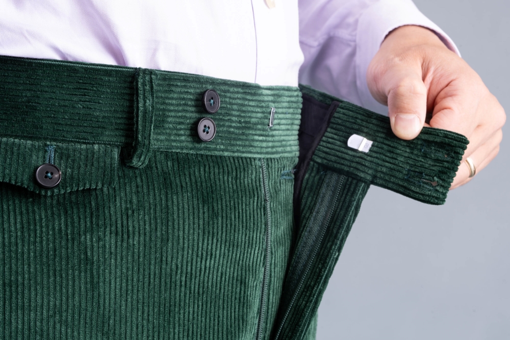 French bearer, metal hook and zip fly on British racing green corduroy trousers